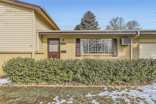 doorway to property featuring a garage and brick siding