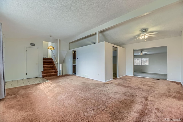 unfurnished living room featuring visible vents, carpet flooring, ceiling fan, a textured ceiling, and stairs