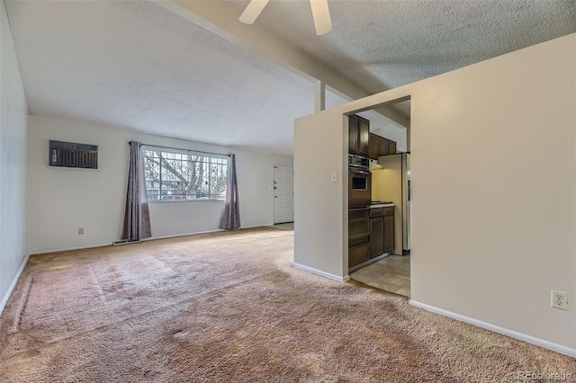 empty room with lofted ceiling with beams, a textured ceiling, light colored carpet, baseboards, and a wall mounted air conditioner