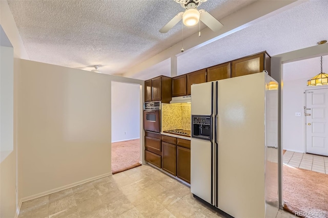 kitchen with white refrigerator with ice dispenser, oven, a textured ceiling, stovetop, and under cabinet range hood