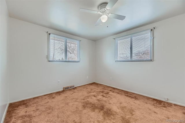 unfurnished room featuring carpet, visible vents, ceiling fan, and baseboards