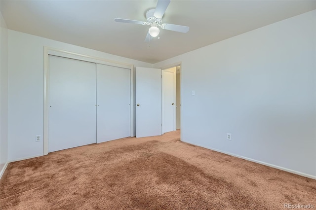 unfurnished bedroom featuring carpet floors, a closet, and a ceiling fan