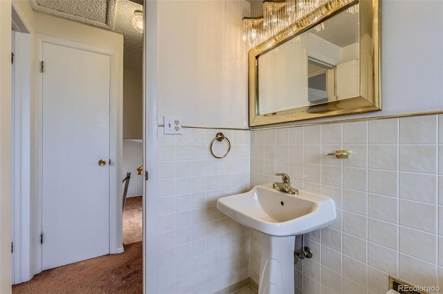 bathroom featuring a wainscoted wall and tile walls