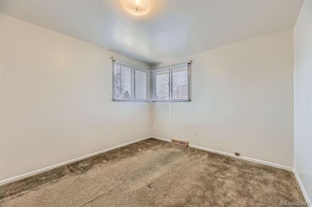 carpeted empty room with visible vents and baseboards