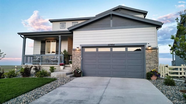 27994 E Indore Dr, Aurora, CO 80016 - view of front of house with a porch, concrete driveway, stone siding, and an attached garage