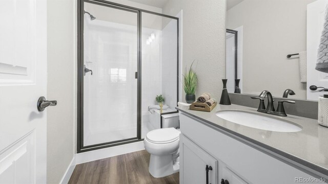 27994 E Indore Dr, Aurora, CO 80016 - bathroom with vanity, a shower stall, and wood finished floors