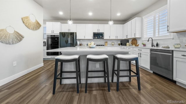 27994 E Indore Dr, Aurora, CO 80016 - kitchen with appliances with stainless steel finishes, decorative backsplash, a breakfast bar, white cabinets, and recessed lighting