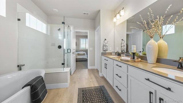 27994 E Indore Dr, Aurora, CO 80016 - ensuite bathroom featuring double vanity, plenty of natural light, a freestanding tub, and a stall shower