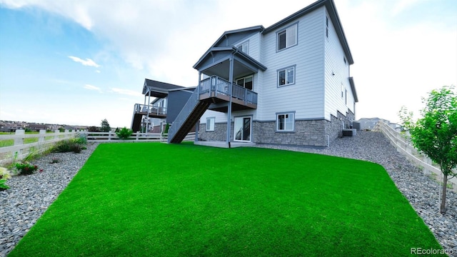 27994 E Indore Dr, Aurora, CO 80016 - rear view of property featuring a fenced backyard, stone siding, stairway, and a wooden deck