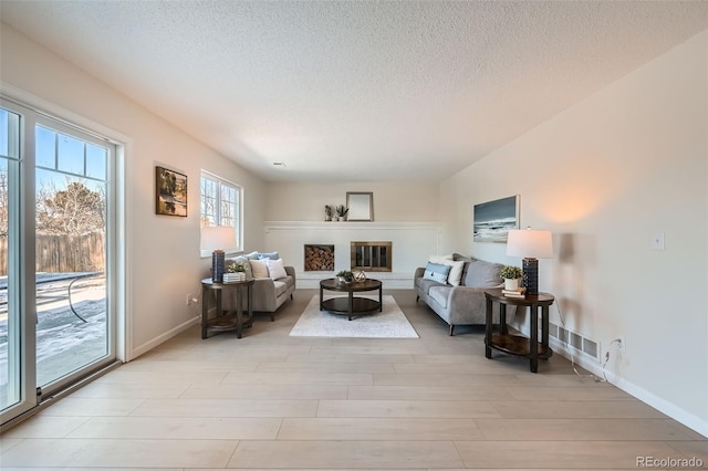 living room featuring light hardwood / wood-style flooring and a textured ceiling