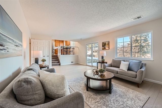 living room featuring light hardwood / wood-style flooring and a textured ceiling