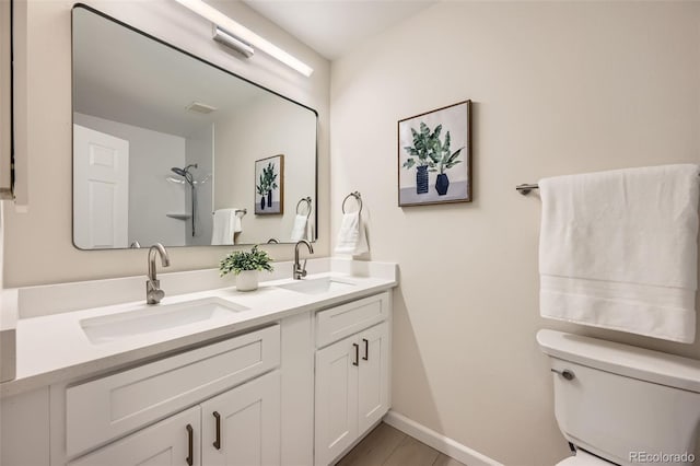 bathroom featuring vanity, a shower, and toilet