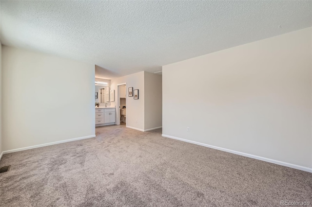 unfurnished room with light colored carpet and a textured ceiling