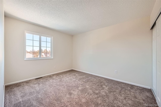 empty room featuring carpet flooring and a textured ceiling