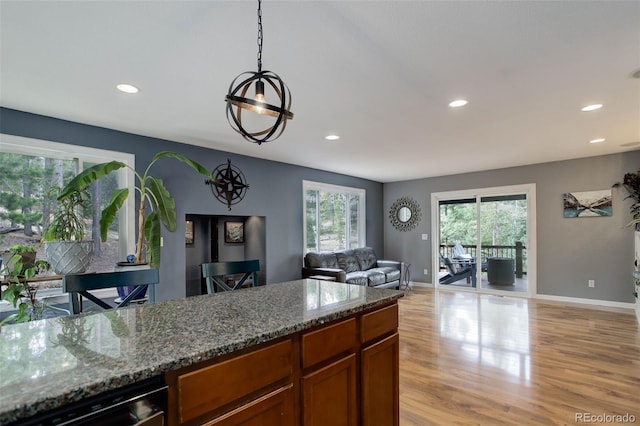kitchen featuring stone counters, brown cabinetry, recessed lighting, and light wood-style flooring