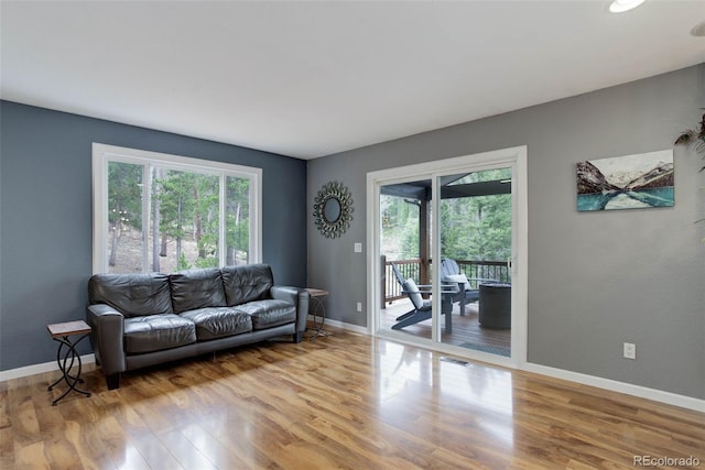 living room featuring plenty of natural light, baseboards, wood finished floors, and visible vents