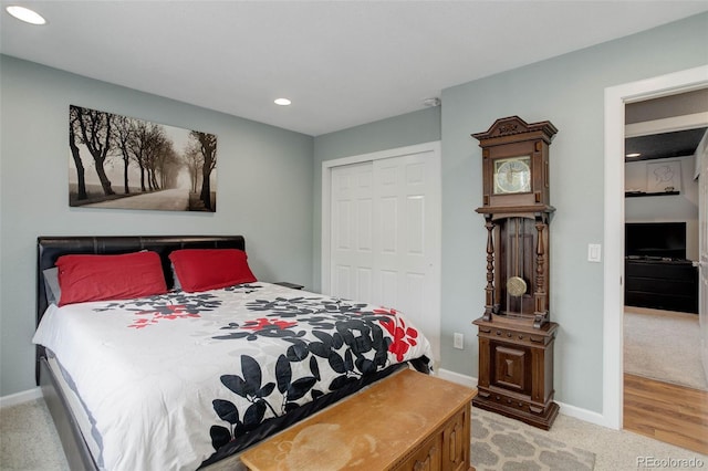 bedroom featuring light colored carpet, recessed lighting, baseboards, and a closet