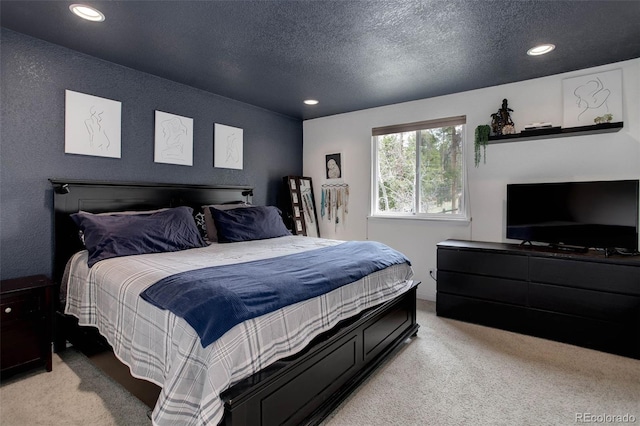 bedroom featuring light carpet, recessed lighting, and a textured ceiling