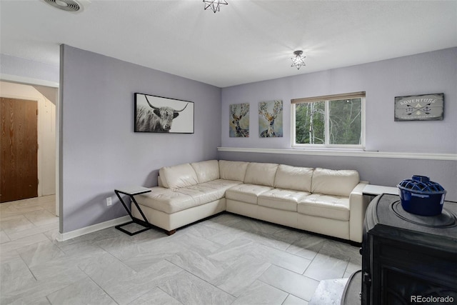 living area with baseboards and visible vents