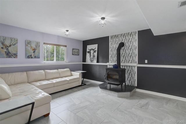 living room with baseboards, a wood stove, and visible vents