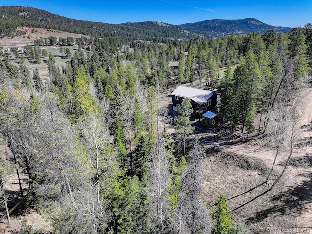 drone / aerial view featuring a forest view and a mountain view