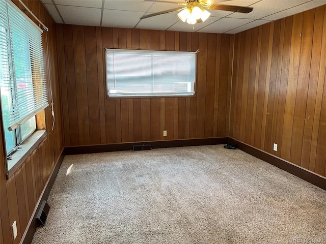 unfurnished room featuring ceiling fan, a paneled ceiling, carpet flooring, and a wealth of natural light