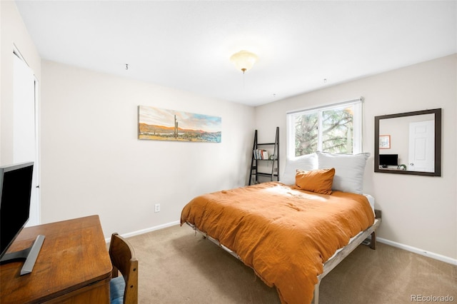 bedroom featuring light colored carpet and baseboards