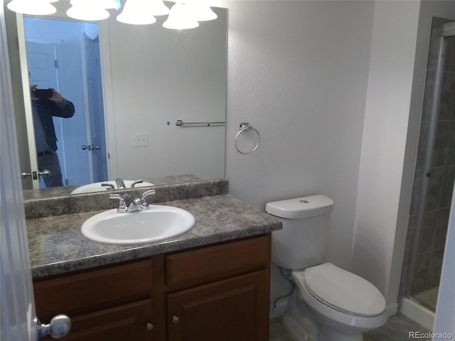 bathroom with walk in shower, vanity, and toilet