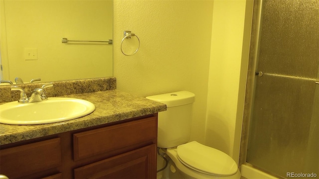 bathroom with walk in shower, vanity, and toilet