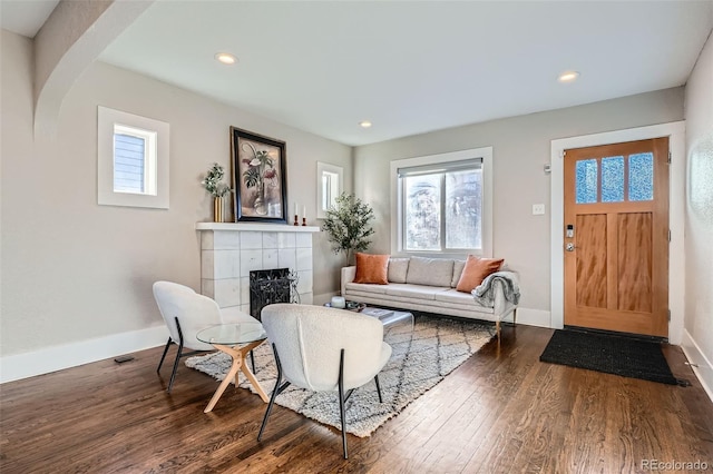 living room featuring plenty of natural light, dark wood-type flooring, and a fireplace