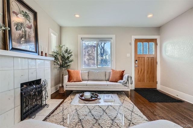 living room with a tile fireplace and light hardwood / wood-style flooring