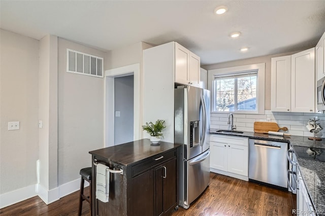 kitchen featuring white cabinetry, appliances with stainless steel finishes, dark hardwood / wood-style flooring, and sink