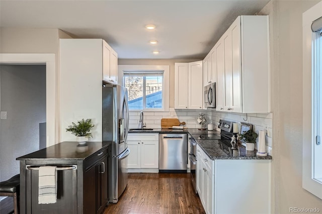 kitchen featuring sink, white cabinetry, tasteful backsplash, dark hardwood / wood-style flooring, and stainless steel appliances