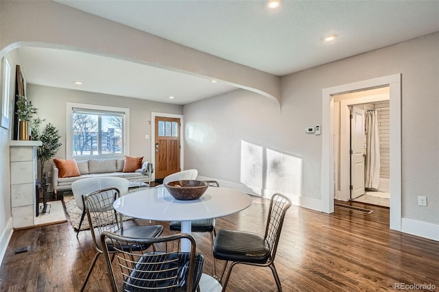 dining space with dark hardwood / wood-style floors and a tiled fireplace