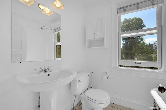 bathroom with tile patterned floors, toilet, and baseboards