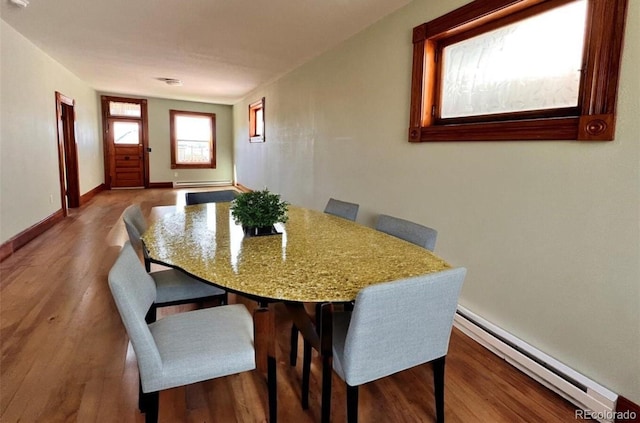 dining space with a baseboard radiator and hardwood / wood-style flooring