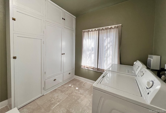 washroom with light tile patterned floors, cabinets, and washing machine and clothes dryer