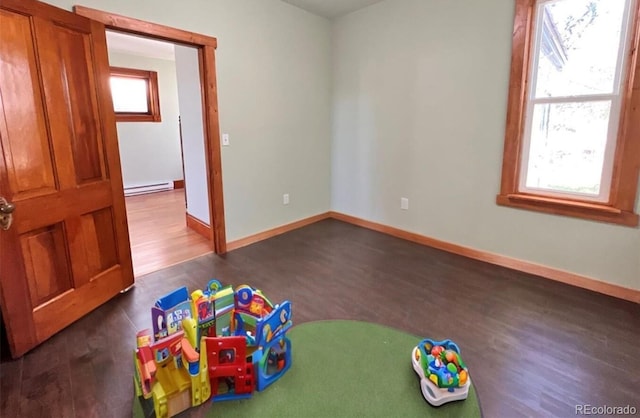 game room featuring dark hardwood / wood-style flooring and a baseboard radiator