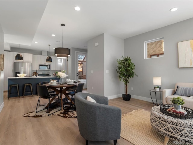 living area with light wood-style flooring, baseboards, and recessed lighting