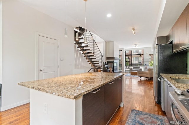 2325 Walnut St Unit 4, Denver, CO 80205 - kitchen with light wood finished floors, a kitchen island, stainless steel range oven, decorative light fixtures, and open floor plan