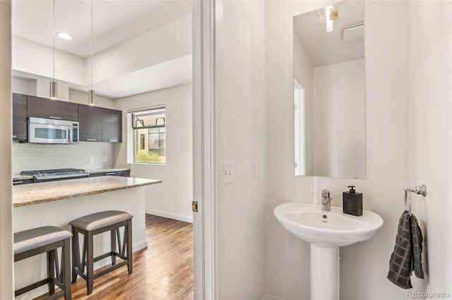 2325 Walnut St Unit 4, Denver, CO 80205 - bathroom featuring backsplash, baseboards, and wood finished floors