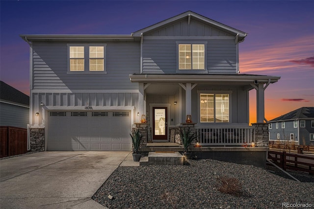 view of front of home featuring driveway, a porch, fence, board and batten siding, and a garage