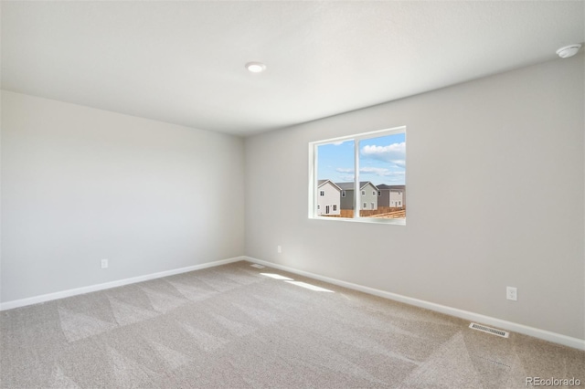 carpeted empty room with visible vents and baseboards