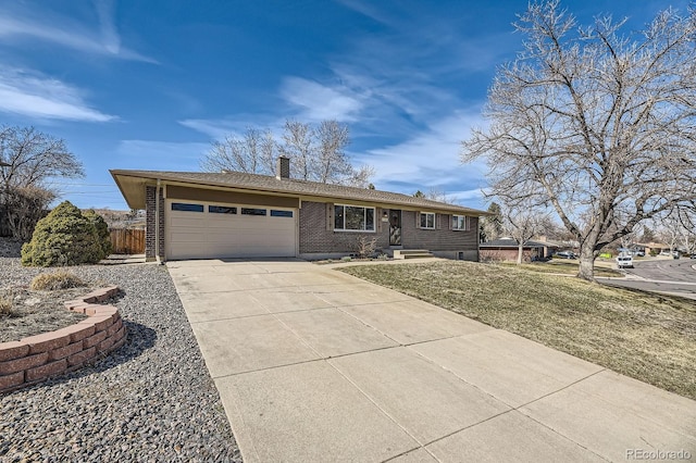 ranch-style home with brick siding, a chimney, concrete driveway, a garage, and a front lawn