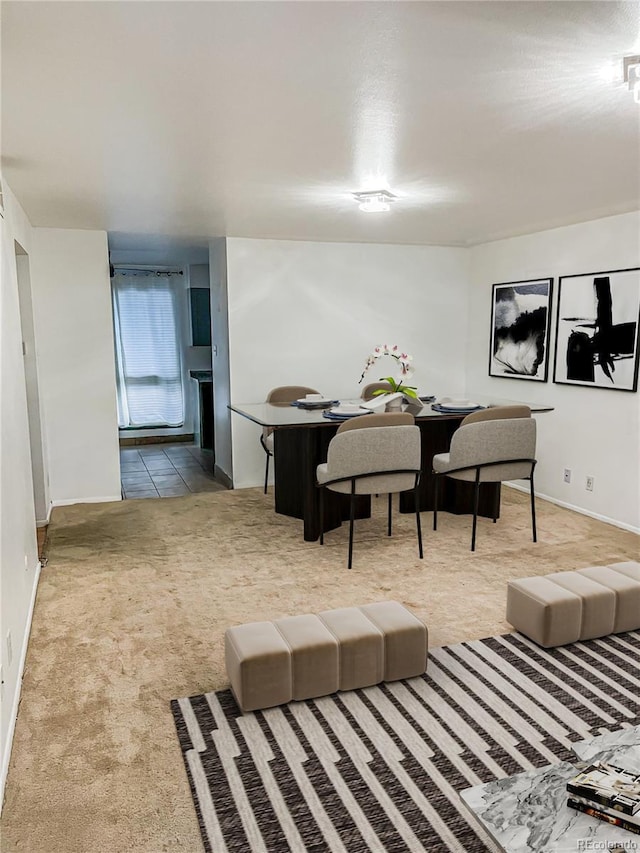 tiled dining space featuring carpet floors