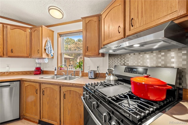 kitchen with under cabinet range hood, light countertops, appliances with stainless steel finishes, a textured ceiling, and a sink