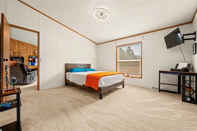 bedroom featuring carpet floors, ornamental molding, a textured ceiling, and vaulted ceiling