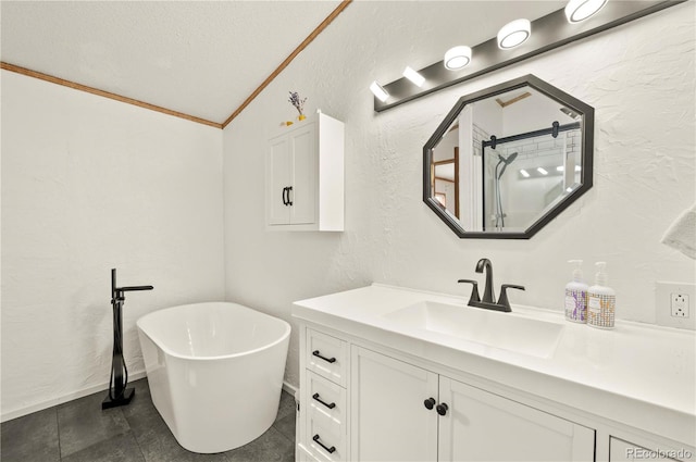 full bath featuring crown molding, vanity, a textured wall, a freestanding tub, and a textured ceiling