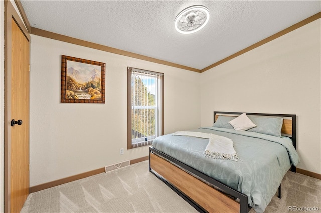 bedroom with a textured ceiling, baseboards, visible vents, and light carpet