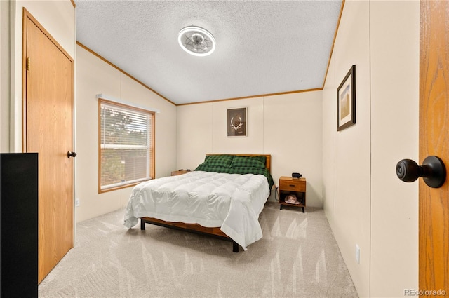 carpeted bedroom featuring a textured ceiling, lofted ceiling, and ornamental molding